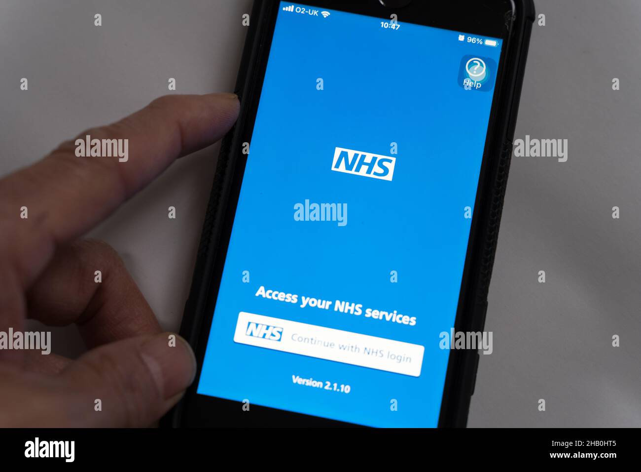 Un homme qui vérifie l'écran de connexion de l'application mobile NHS pour accéder aux services NHS de l'Angleterre Banque D'Images