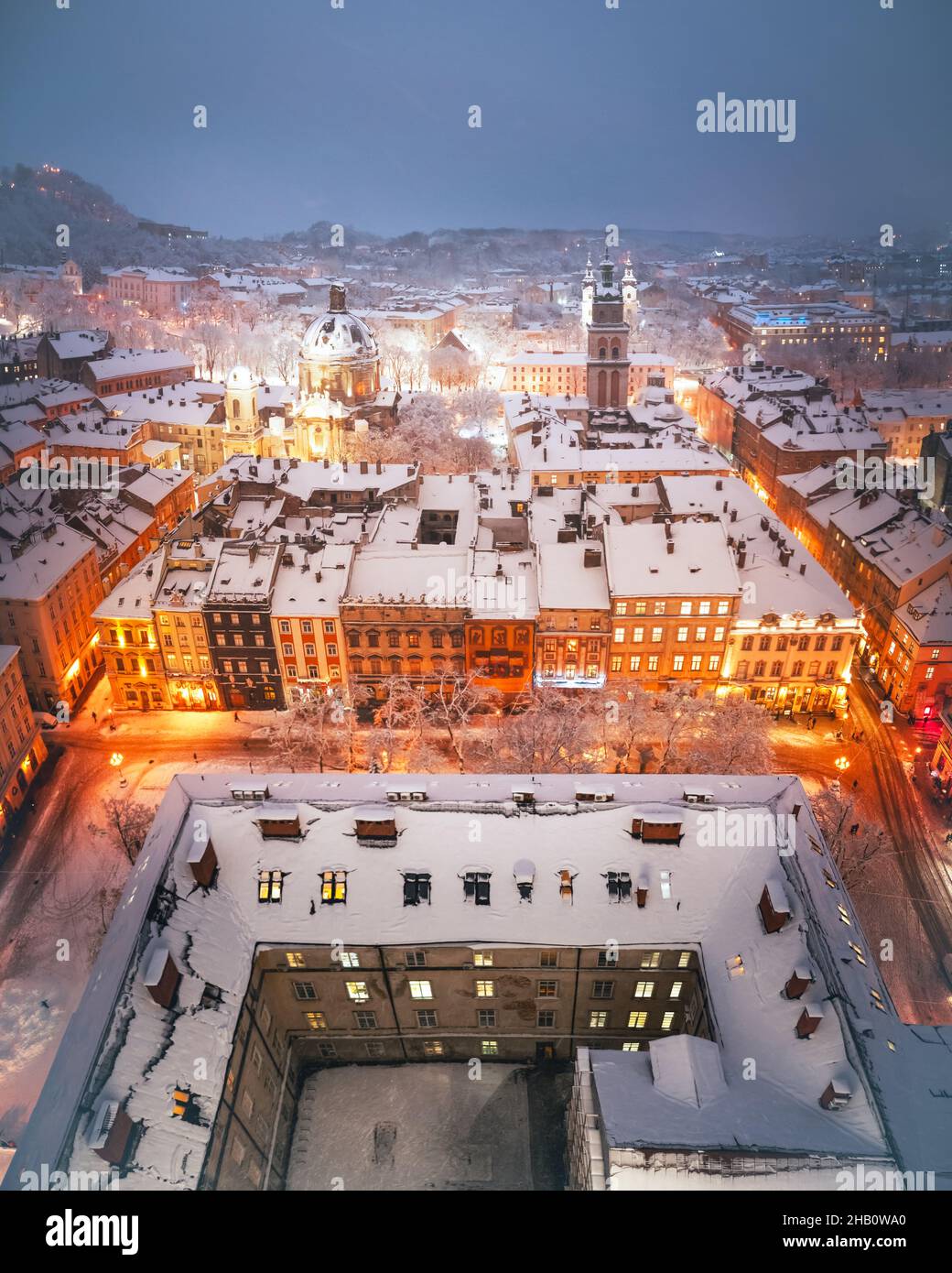 Magnifique paysage urbain d'hiver ville de Lviv illuminée par les lumières de la ville avec des toits couverts de neige du sommet de l'hôtel de ville, Ukraine, Europe.Photographie de paysage Banque D'Images