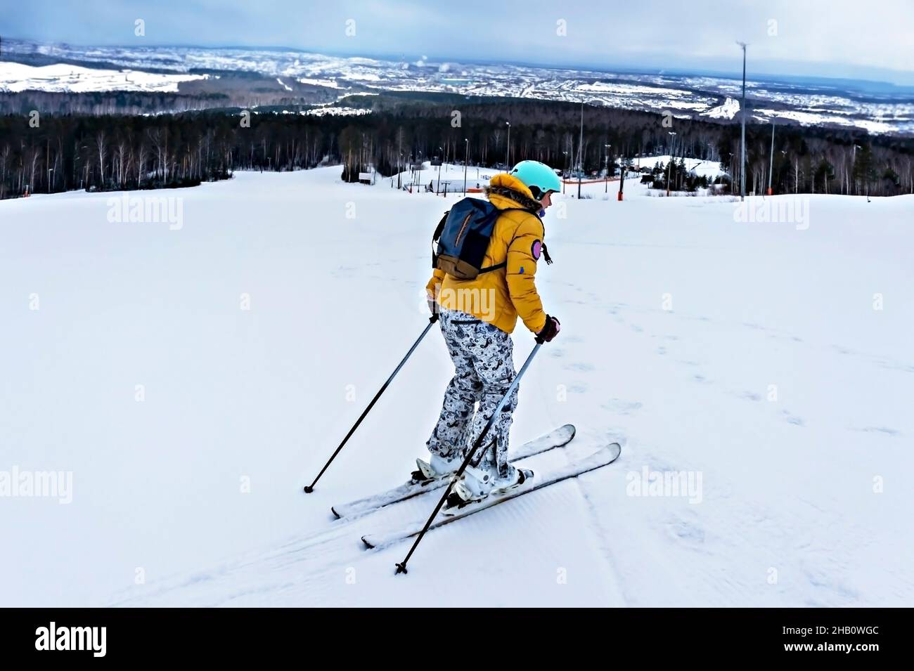 Jeune femme en blouson jaune et casque de ski ski ski ski sur une piste de montagne, sports d'hiver, ski alpin en plein air, un mode de vie sain et actif Banque D'Images