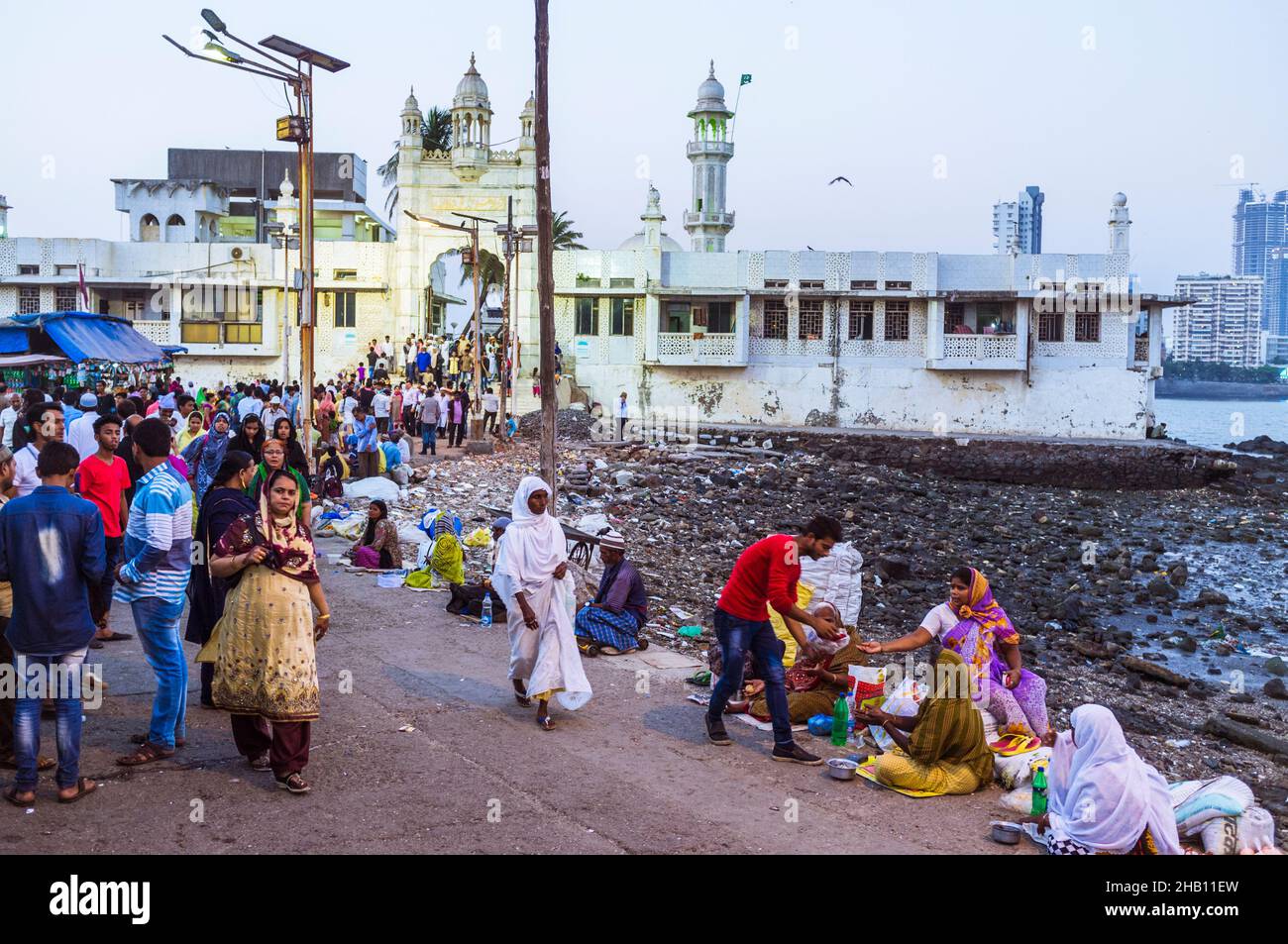 Mumbai, Maharashtra, Inde : Un pèlerin donne des almes aux mendiants, en se bordant sur la chaussée menant au 19th siècle Haji Ali Dargah et à la mosquée (en bac Banque D'Images