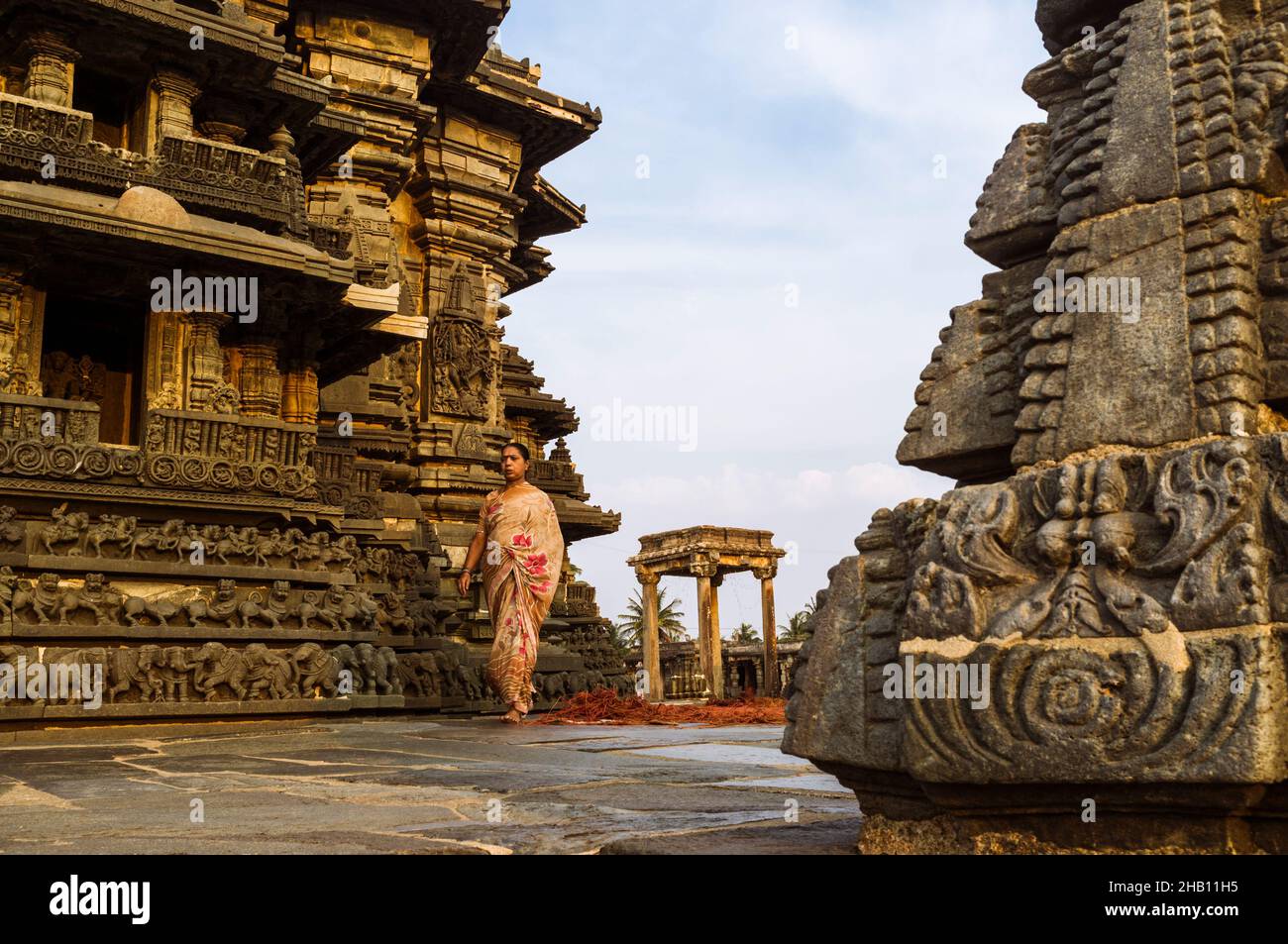 Belur, Karnataka, Inde : Temple Chennakhava du 12th siècle.Une femme marche sur la plate-forme jagati pour la cirambulation (pradakshina-patha) autour de la Banque D'Images