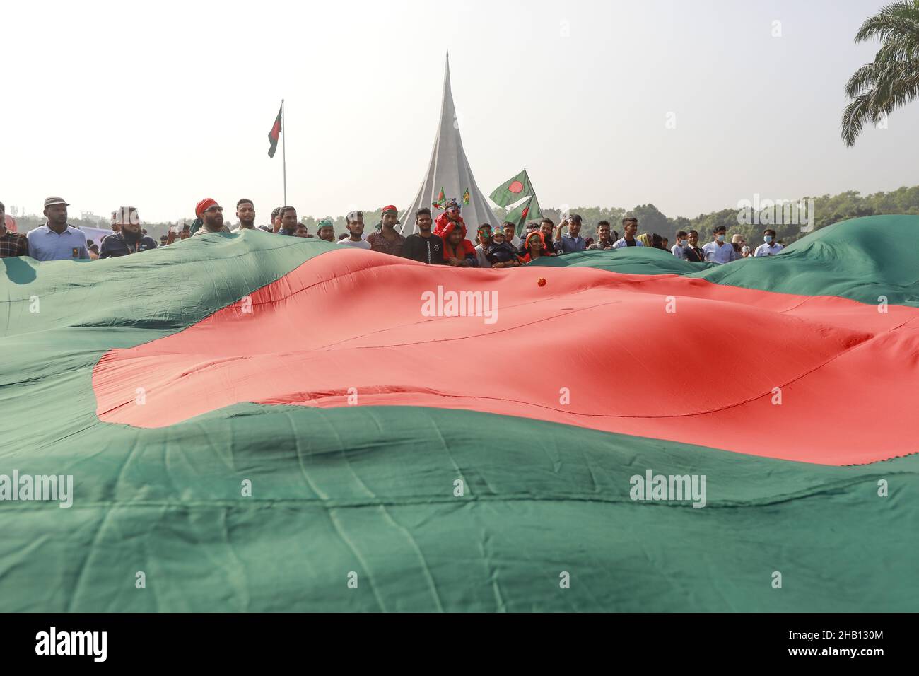 Les gens brandisent des drapeaux nationaux alors qu'ils se rassemblent pour rendre hommage au mémorial national des martyrs de la guerre d'indépendance de 1971 pour célébrer le jour de la victoire de 50th, qui marque la fin d'une guerre amère d'indépendance de neuf mois à Savar, le 16 décembre 2021.Le Bangladesh célèbre le 50th anniversaire de sa victoire nationale, en rappelant les vaillants combattants de la liberté qui ont combattu et fait le sacrifice ultime pour libérer le pays des forces pakistanaises.Les gens de tous les milieux ont commencé à se rassembler au Mémorial national du matin jeudi pour rendre leurs respects au m Banque D'Images