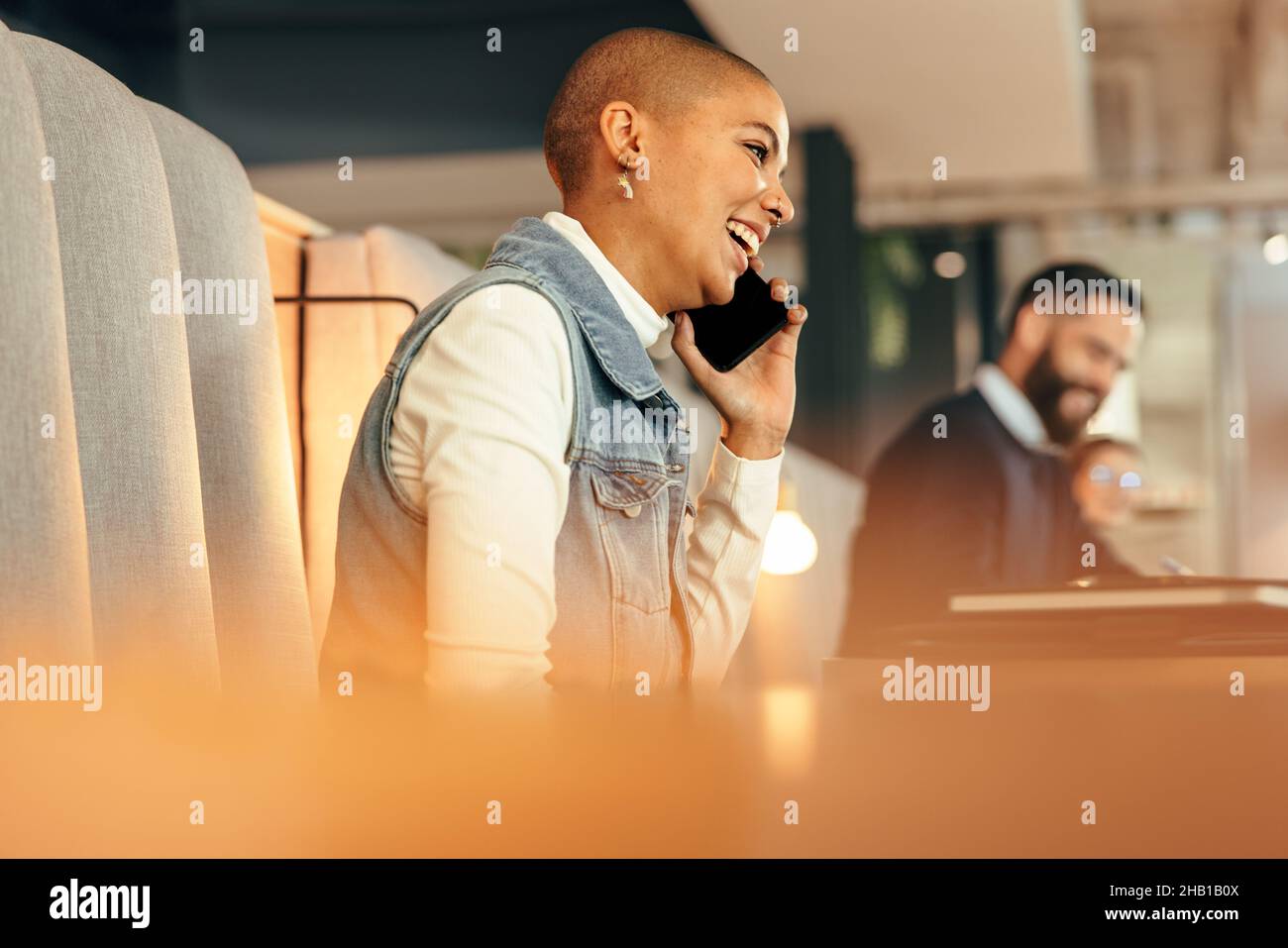 Femme d'affaires créative parlant au téléphone dans un espace de travail conjoint.Une jeune femme d'affaires heureuse communique avec ses collaborateurs lors d'un appel téléphonique.Fémal Banque D'Images