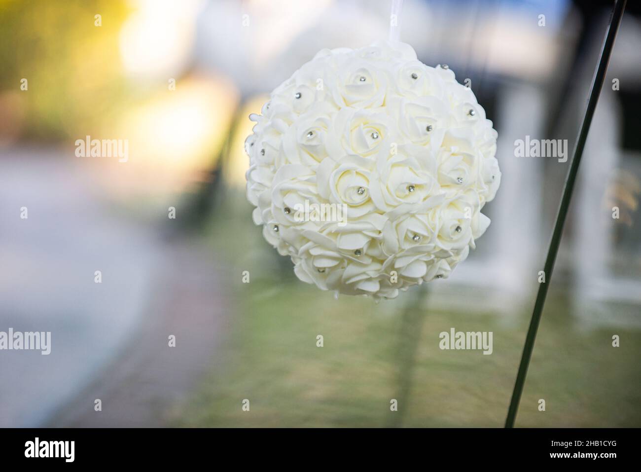 Boule de fleurs blanches avec décoration de diamants accrochée à l'isle lors d'une cérémonie de mariage en plein air Banque D'Images