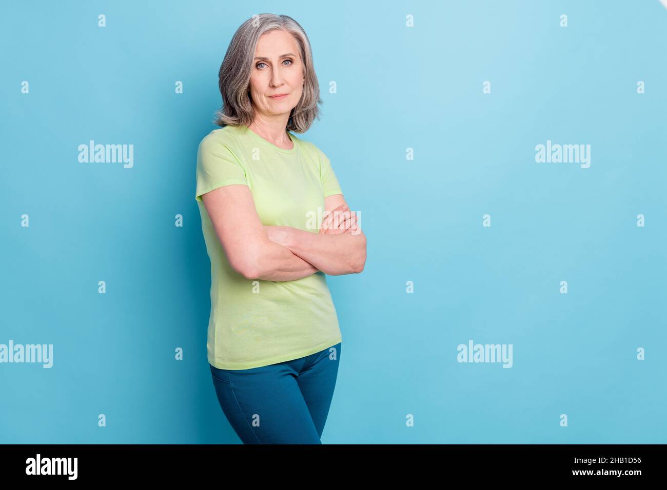 Photo de sérieux confiant jolie charmante vieille femme tient les mains croisées isolées sur fond bleu pastel Banque D'Images