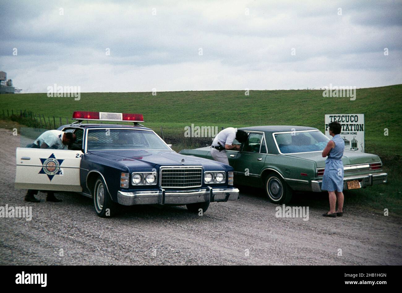 Officiers de l'Ascension Parish Sherrif's Office aidant les touristes enfermés de voiture de location Gonzales, Louisiane, Etats-Unis 1976 Banque D'Images