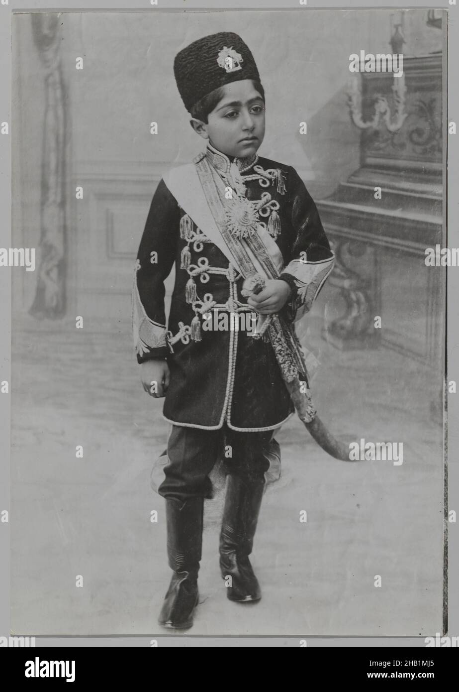 Portrait de Malijak Aziz al-Sultan ou Ahmad Shah en tant que jeune garçon, une des 274 photographies anciennes, photo d'argent Gelatin, ca.1890 ou 1900-1905, Qentra, période Qentra, 6 1/2 x 4 9/16 po., 16,5 x 11,6 cm, noir et blanc, garçon, cérémonial, formel,Iran, médaillon, militaire, persan, photographie,Portrait, Qentra, régal, regalia, royal,Royauté, Shah, soldat, studio, toile de fond de studio,Épée, uniforme, Jeune soldat Banque D'Images
