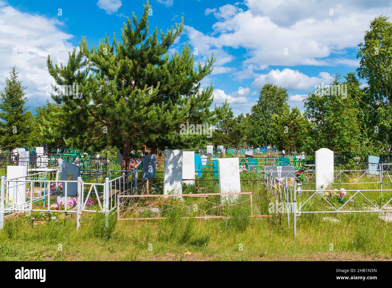 Gros plan de tombes et d'arbres dans le cimetière de Zaykovskoye, dans la journée ensoleillée d'été, à Kourgan, en Russie Banque D'Images