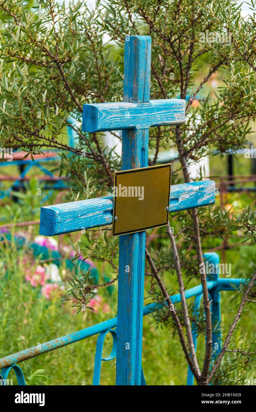 Une grave croix avec plaque signalétique dans le cimetière de Zaykovskoye en été ensoleillé, Kurgan, Russie Banque D'Images