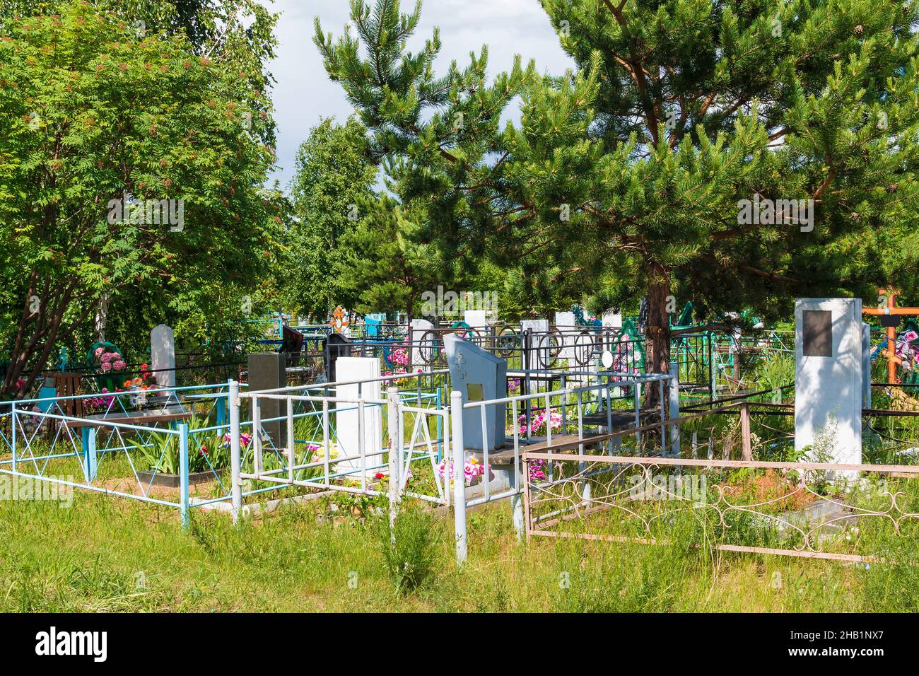Gros plan de tombes et d'arbres dans le cimetière de Zaykovskoye, dans la journée ensoleillée d'été, à Kourgan, en Russie Banque D'Images