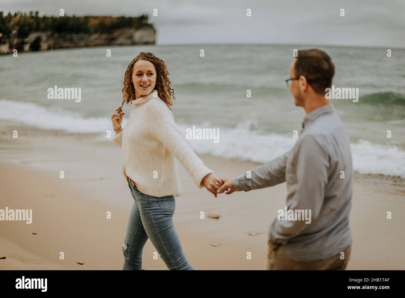 La femme regarde le dos tient les mains avec un petit ami le long de la rive du lac, Michigan Banque D'Images