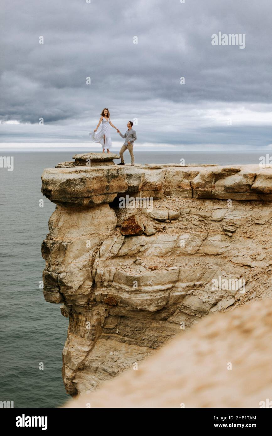 Le couple se trouve sur le bord de la spectaculaire falaise photographiée Rocks Lakeshore Banque D'Images