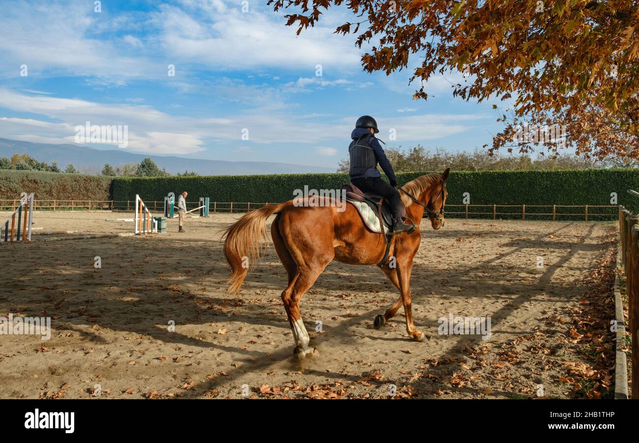 Enfant à cheval au ranch avec des obstacles et des barrières. Banque D'Images