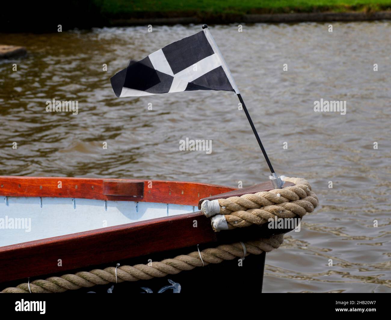 Le drapeau cornish (St Piran's) volant sur l'arc d'un bateau, Bude, Cornwall, Royaume-Uni Banque D'Images