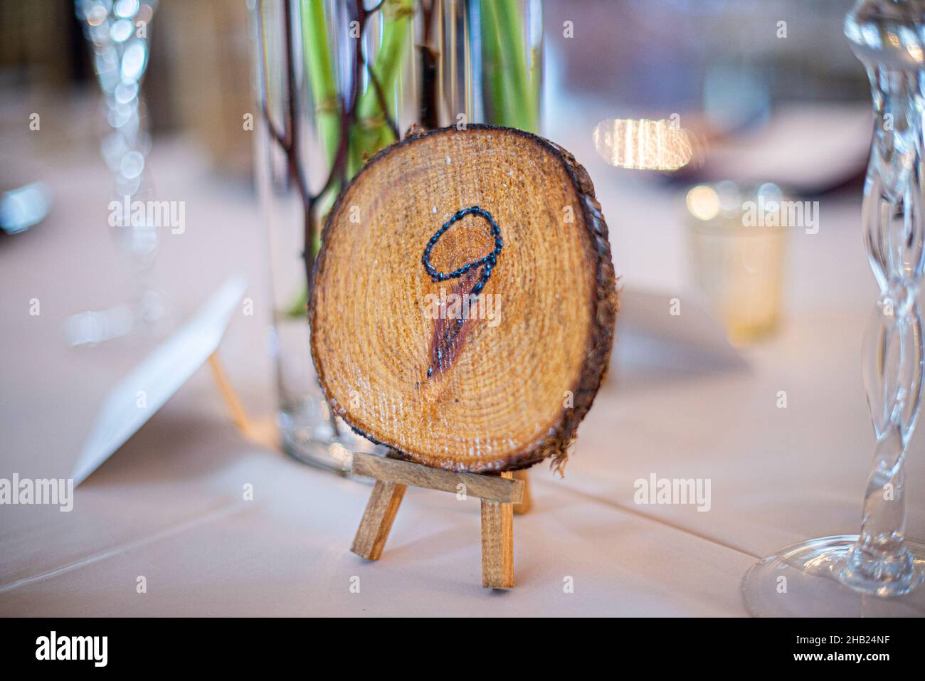 Souche de bois avec le numéro neuf gravé sur la table indicateur de place à la table de réception de mariage Banque D'Images