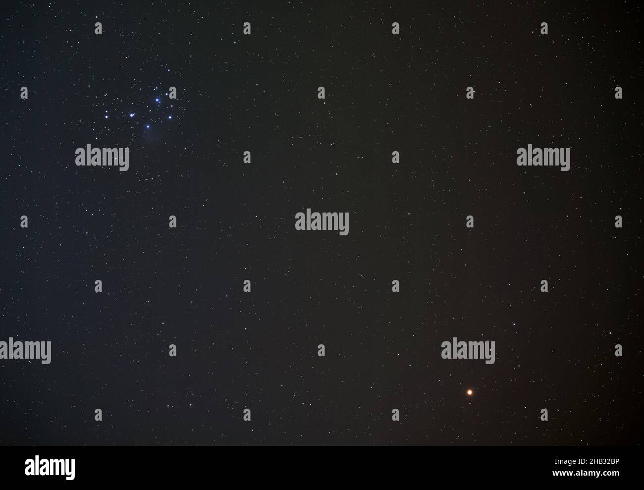 Pléiades (également connu sous le nom de Seven Sisters), groupe d'étoiles ouvert sur le ciel nocturne d'hiver, planète Mars rouge vif dans le coin inférieur droit, photo longue exposition Banque D'Images