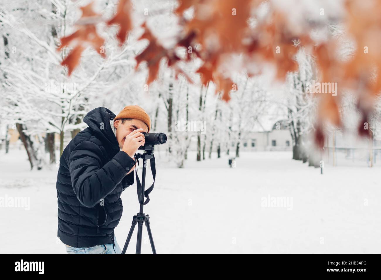 Photographe prenant des photos à l'aide d'un appareil photo numérique professionnel sur trépied dans un parc hivernal enneigé.Photos de paysage.Photographie en extérieur.Passe-temps Banque D'Images