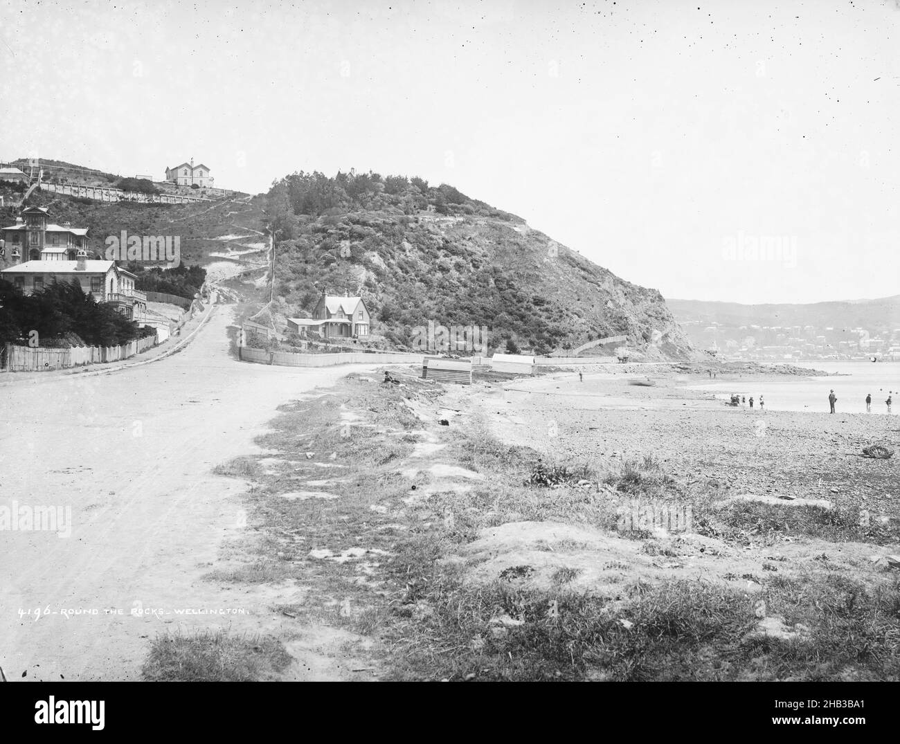 Round the Rocks, Wellington, Burton Brothers studio, studio de photographie, 1880s,Dunedin, photographie en noir et blanc, vue le long de la route à côté d'une plage, colline jusqu'à la route.Wellington ville au loin Banque D'Images