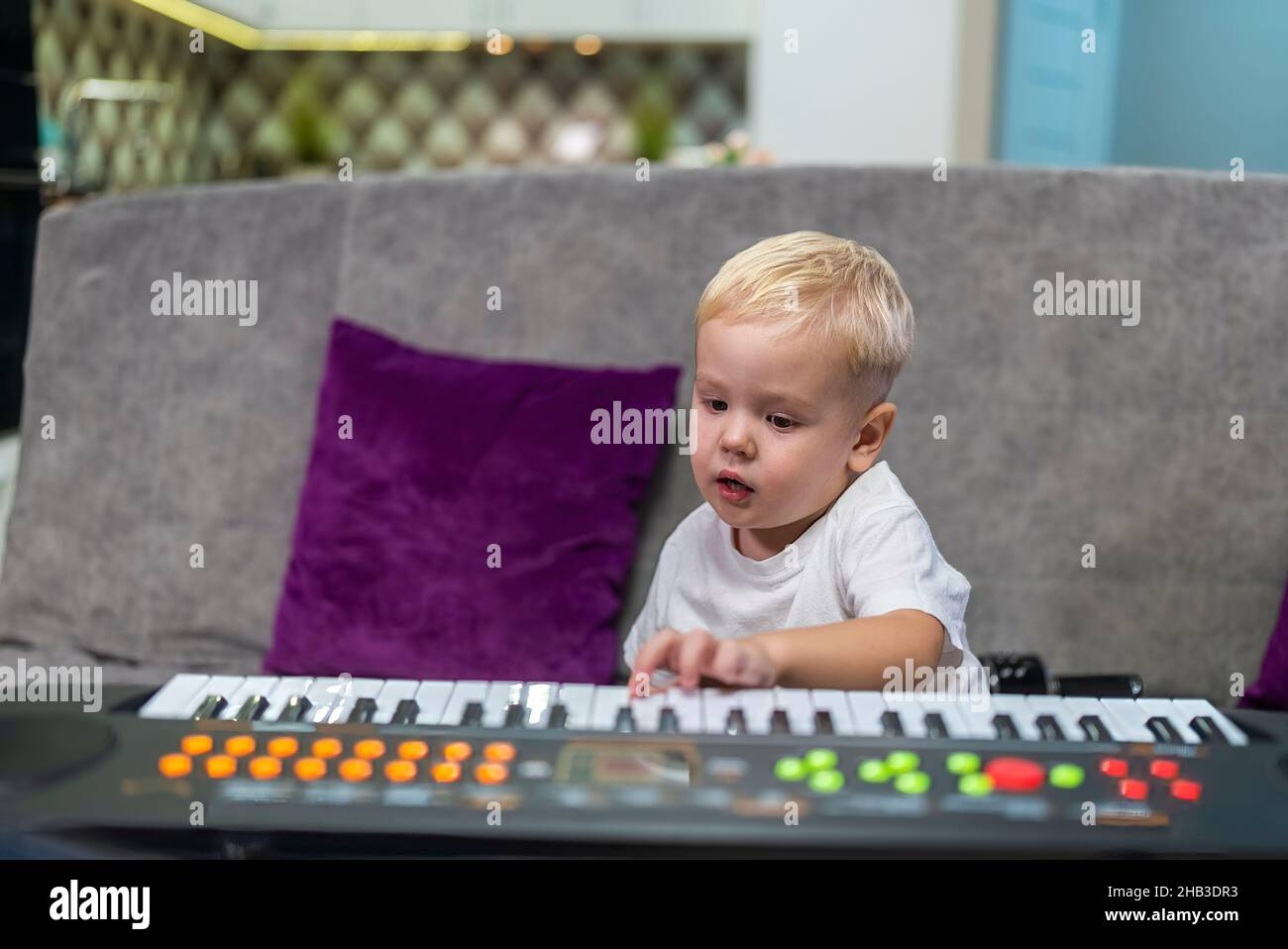 petit garçon apprenant à jouer du piano à la maison Banque D'Images