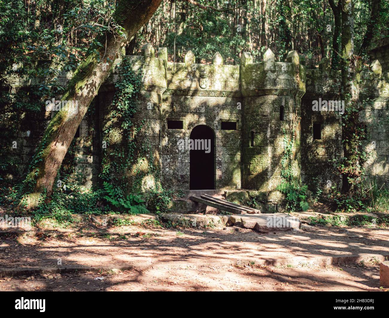 Gros plan d'un château de pierre de mousse d'époque dans la forêt par une journée ensoleillée à Bosque Encantado, Espagne Banque D'Images