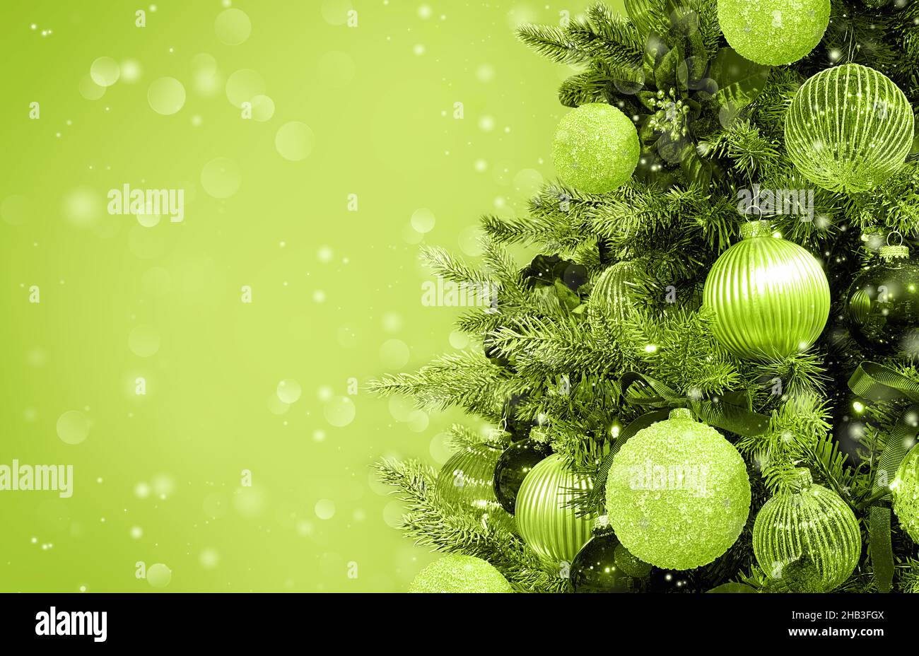 Sapin de Noël avec ornements, boules et lumières.Arrière-plan monochrome vert vacances Banque D'Images