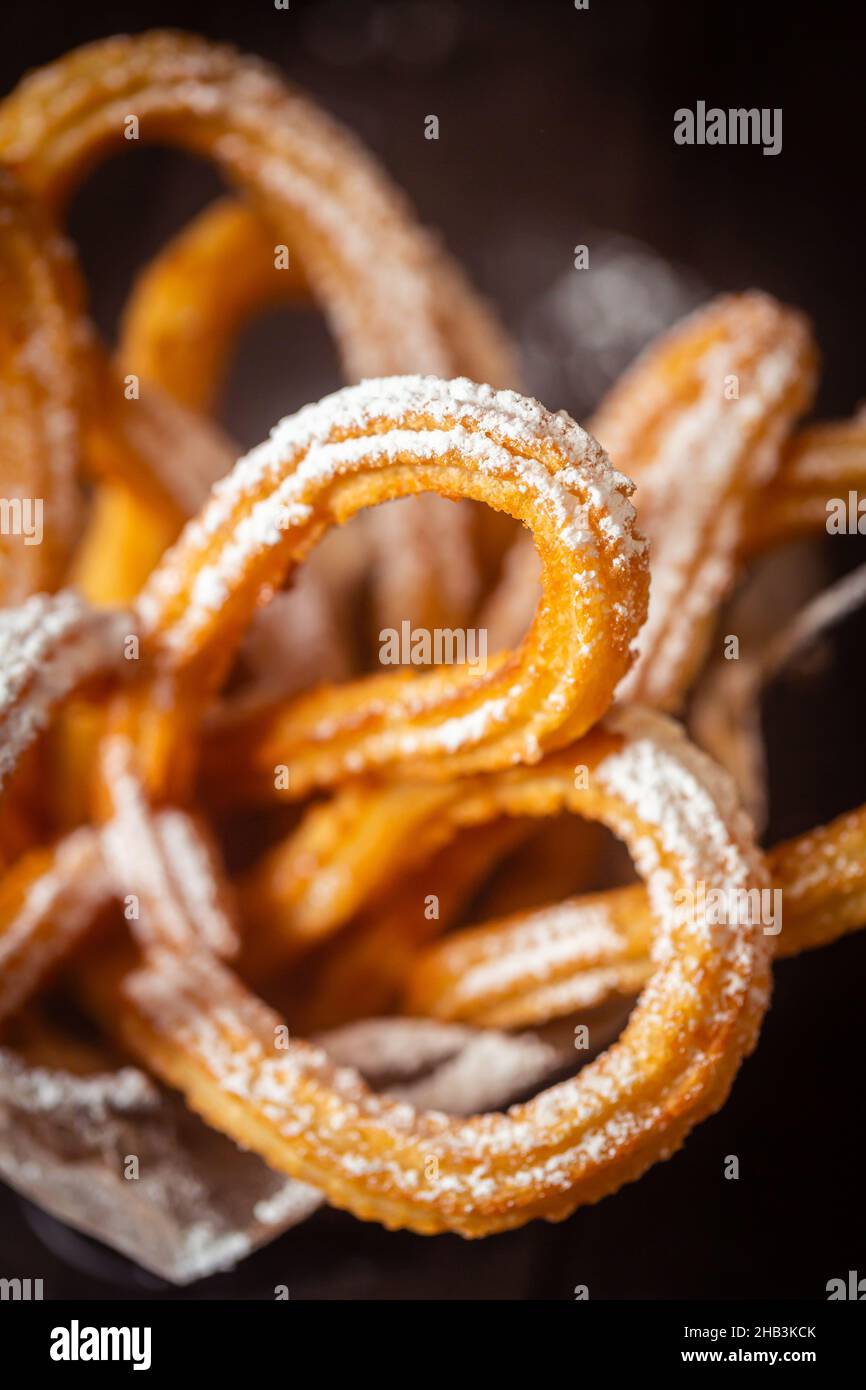 Des churros espagnols traditionnels sur la table.Photo sombre et sinistre, style rustique, gros plan Banque D'Images