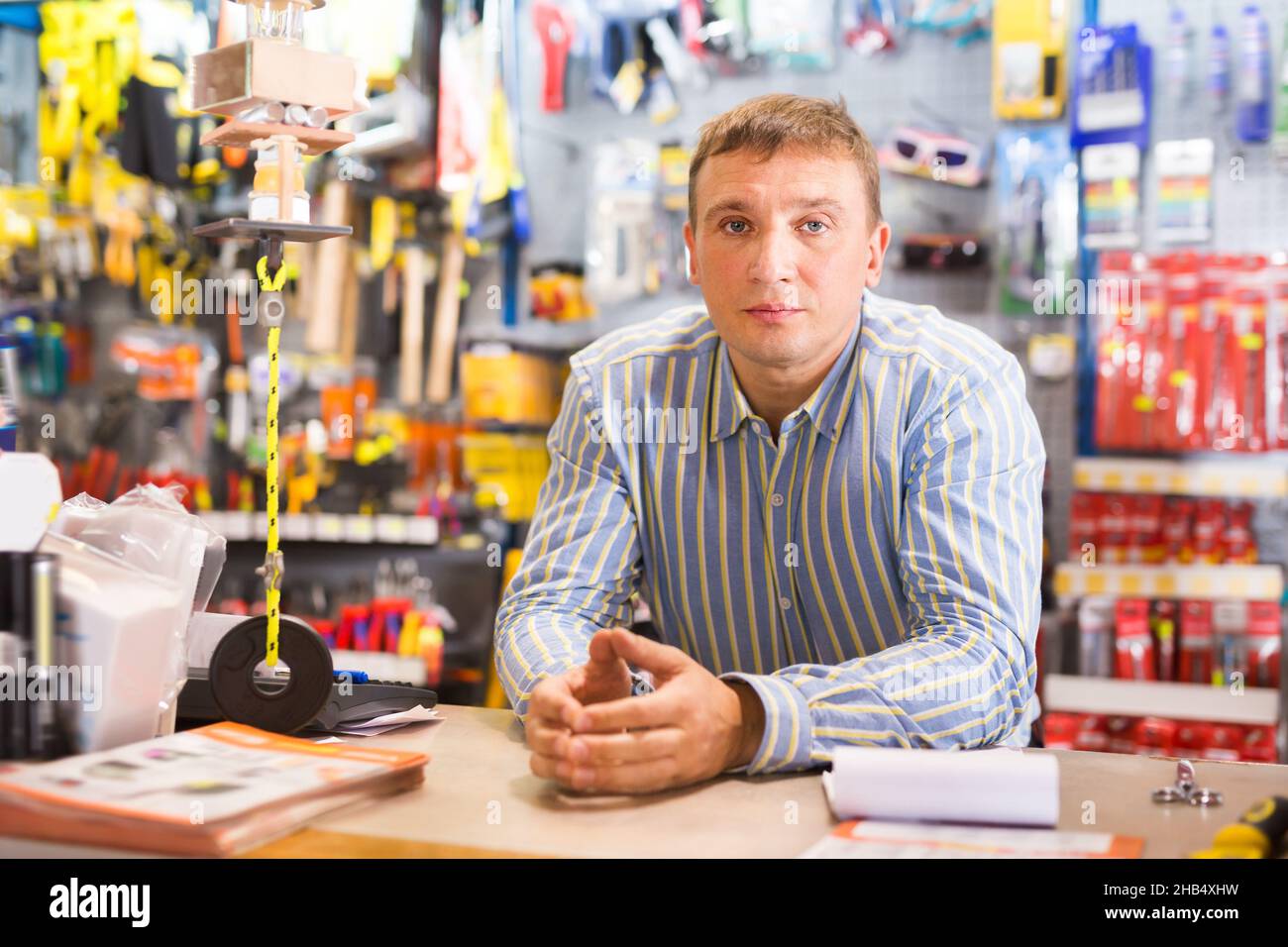 Vendeur positif homme en magasin est des outils de négociation Banque D'Images