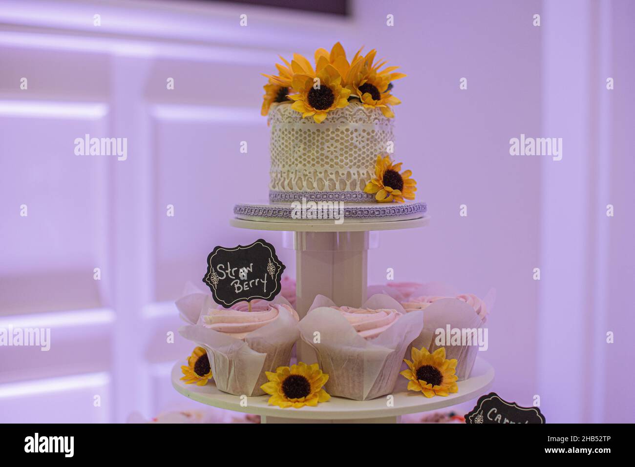 Magnifique gâteau de mariage décoré de dentelle et de tournesols au sommet de la tour de cupcake Banque D'Images