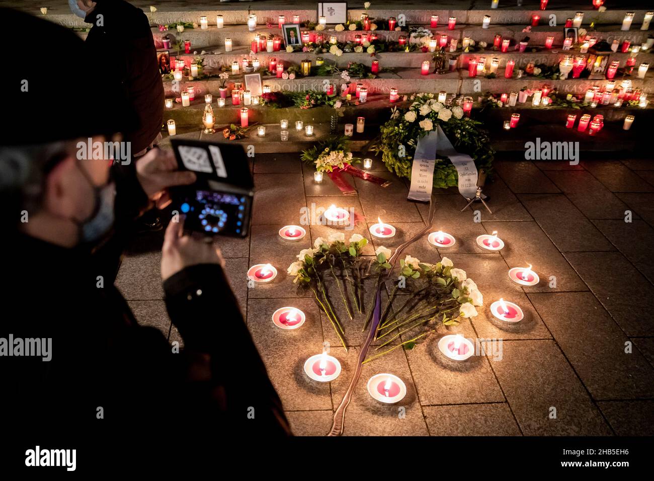 CLASSÉ - 19 décembre 2020, Berlin: Un homme prend une photo du mémorial du 'Golden Rift', où de nombreuses bougies ont été posées, y compris des bougies et des roses blanches en forme de coeur, pendant le service commémoratif du quatrième anniversaire de l'attaque islamiste sur le marché de Noël de Breitscheidplatz.Le président allemand Steinmeier, le président du Bundestag Bas (SPD) et le maire de Berlin Müller (SPD) sont attendus dimanche soir pour le cinquième anniversaire de l'attentat.Steinmeier et Müller prononceront de brefs discours lors d'un service de l'Eglise du souvenir; le sermon sera donné par Protstan Banque D'Images
