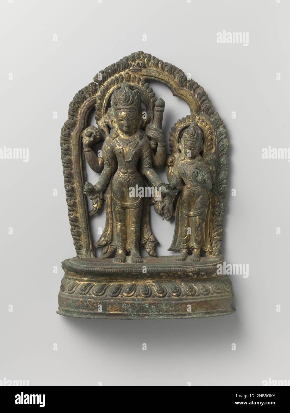 Image du couple de dieu Vishnu et Shri, image du couple de dieu Vishnu et Shri.Entourés d'un halo, les deux divinités se trouvent sur une base de lotus.Vishnu a quatre bras avec un disque de projection et une coquille de conch dans ses mains droites et un club et lotus dans sa gauche.La déesse a deux bras; avec la main droite elle fait le geste de donner et avec la gauche de l'enseignement., Népal, 1600 - 1699, cuivre (métal), dorure (matériel),martelage, dorure, hauteur 28 cm × largeur 18,8 cm × profondeur 4,5 cm Banque D'Images