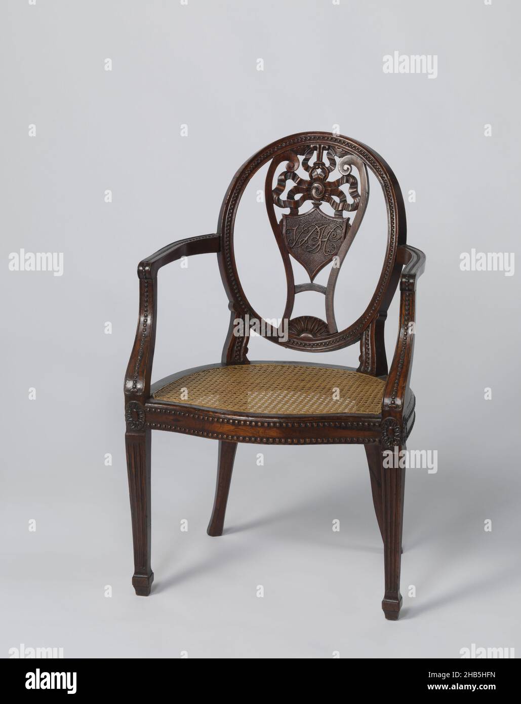 Fauteuil, fauteuil avec dossier ovale incurvé et assise de tapis.Le panneau central est ouvert sous la forme d'une lyre avec un blason dans lequel les lettres VBH (Van Braam Houckgeest) sont en relief.Sur le dossier, les accoudoirs et les jambes de bras une bordure en perle; pieds avant cannelés et rosettes au-dessus des jambes., ouvrier du mobilier: Anonyme, Chine, 1795, teck (bois),rotin, laquage, hauteur 89,0 cm × largeur 55,1 cm × profondeur 59,5 cm largeur 55,0 cm × profondeur 41,0 cm poids 6 kg Banque D'Images