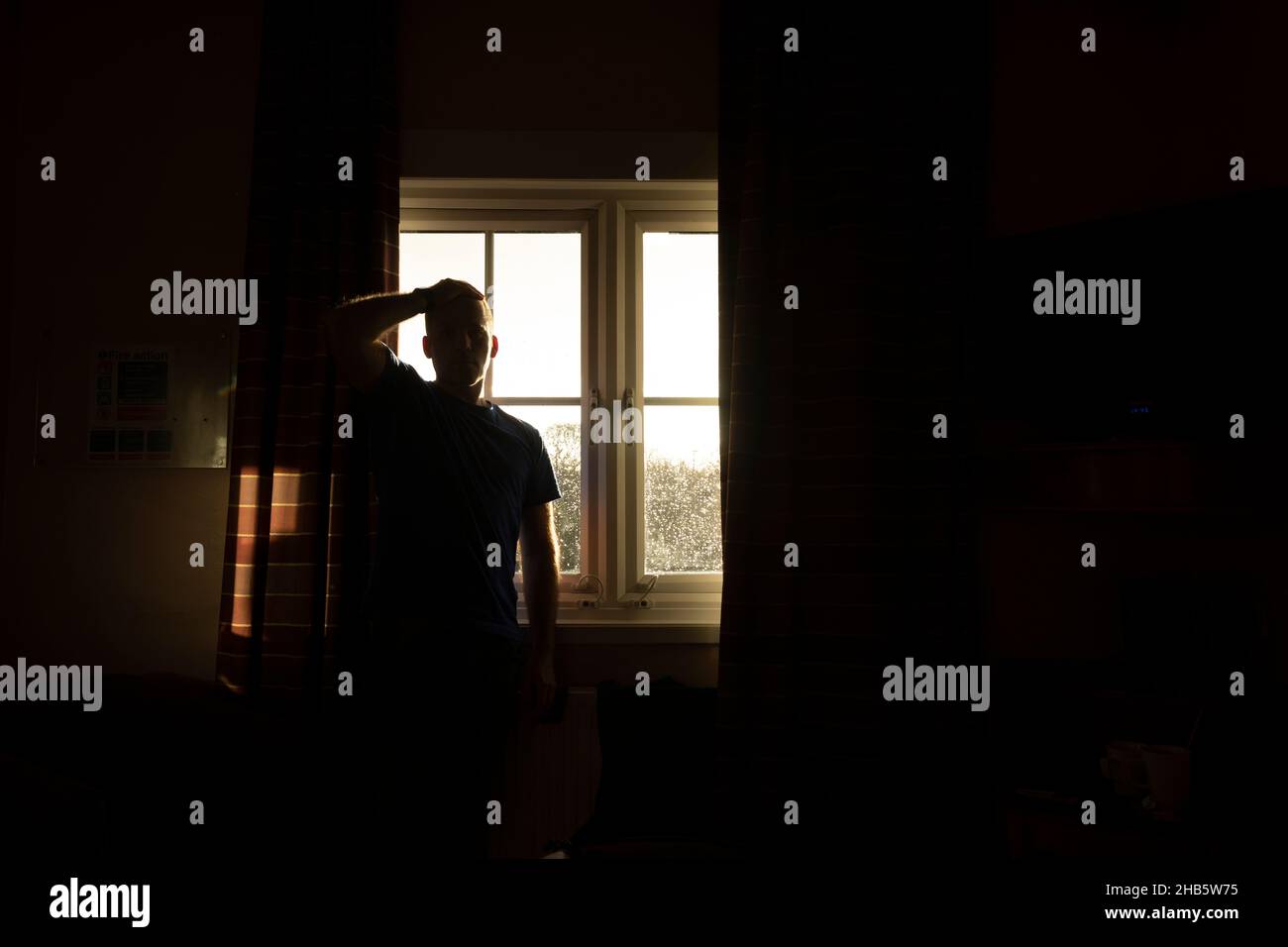 Un homme, d'âge moyen, adulte, attend les résultats d'un test pcr Covid-19, auto-isolé, dans une chambre d'hôtel près de l'aéroport de Manchester, Royaume-Uni Banque D'Images