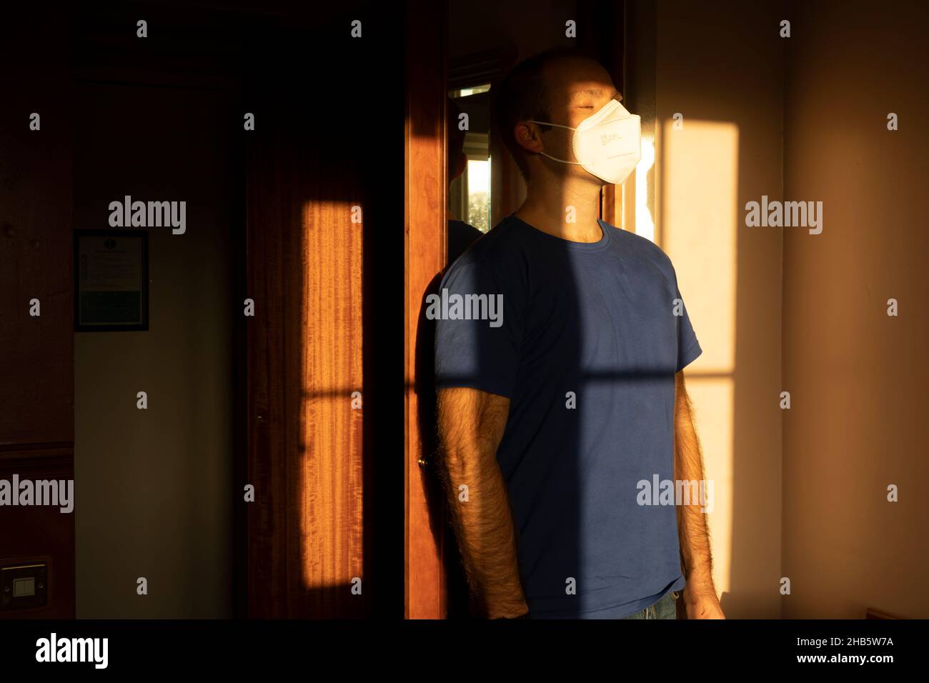 Un homme, auto-isolé, avec un masque facial, se tient devant les dernières lumières silencieuses de la journée, près de l'aéroport de Manchester, au Royaume-Uni, tout en attendant les résultats de Banque D'Images