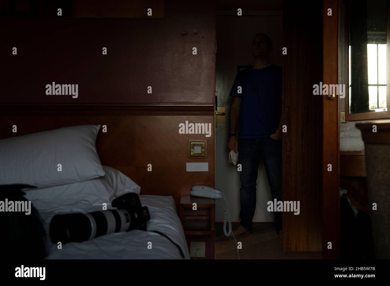 Un homme, auto-isolé, dans la solitude, dans une chambre d'hôtel, près de l'aéroport de Manchester, Royaume-Uni, attend les résultats d'un test pcr Covid-19 qui libéra Banque D'Images