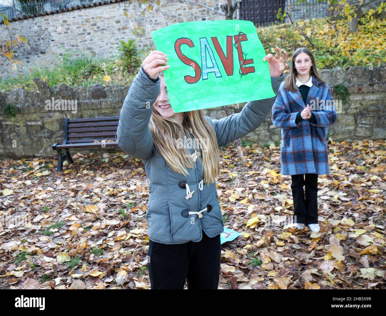 Écologiste enfants filles jouant pour sauver la planète comme le mal toxique pollue la terre représentée par la violette persona actrice Antonia Stradivari Banque D'Images
