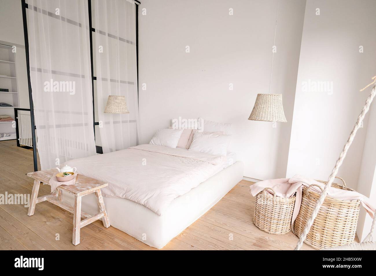 chambre rose pâle dans un style minimaliste avec un lit double avec des espaces pour les vêtements et pour dormir.Photo de haute qualité Banque D'Images
