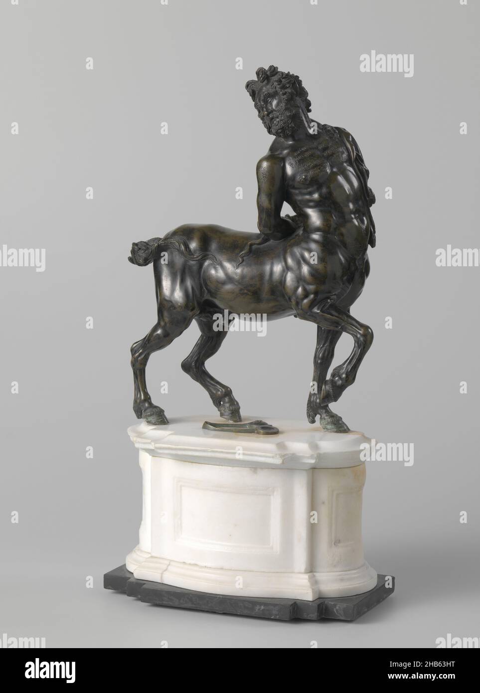 Un jeune et un ancien Centaur, un ancien Centaur, le Centaur marche à un rythme de marche avec la jambe avant droite relevée et les poignets attachés derrière son dos.Il tourne son corps supérieur avec sa tête au-dessus de l'épaule droite et projette son regard vers l'arrière.La tête montre des cheveux bouclés, une barbe et des oreilles pointues.Au-dessus de l'épaule gauche se trouve la peau d'un prédateur, dont la queue se trouve au-dessus de la bosse du cheval.La queue du centaure bat contre le flanc droit, la poitrine est poilue, dans le creux du dos une touffe de cheveux.Entre les pieds se trouve une paire de calanets sur une ceinture.Avec base ovale., sculpteur: Anonyme, Rome, c Banque D'Images