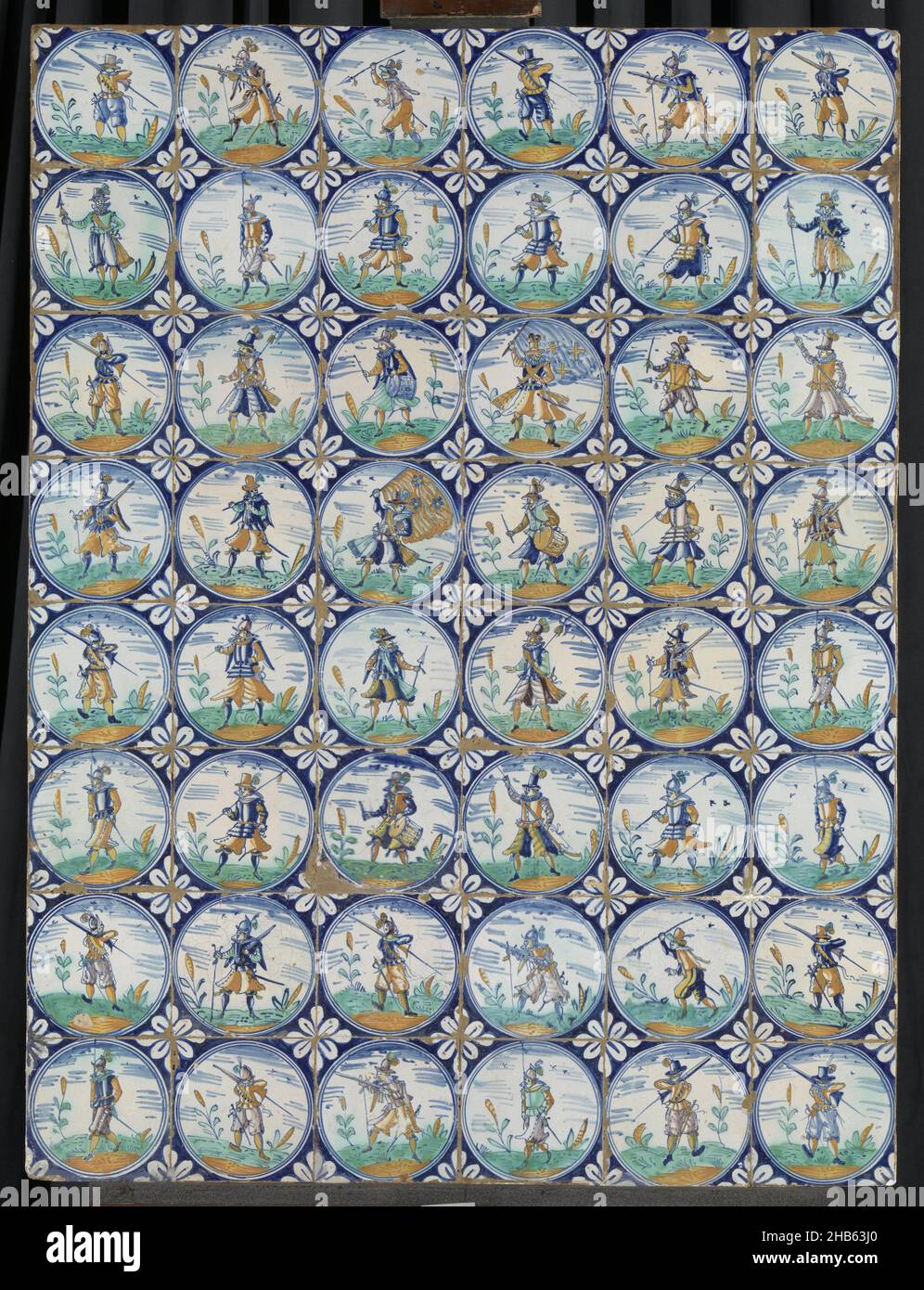 Champ de quarante-huit tuiles peintes multicolores avec un guerrier avec musket ou halberd dans un cercle, champ de quarante-huit tuiles (8 x 6) chacune avec un guerrier multicolore (bleu, orange, vert, jaune et violet) avec musket ou halberd dans un cadre circulaire.Dans les coins, feuilles en technique de remplissage., anonyme, pays-Bas, c.1580 - c.1625, faïence, glaçure d'étain, majolica, hauteur 108,5 cm × largeur 81,5 cm × profondeur 5 cm Banque D'Images