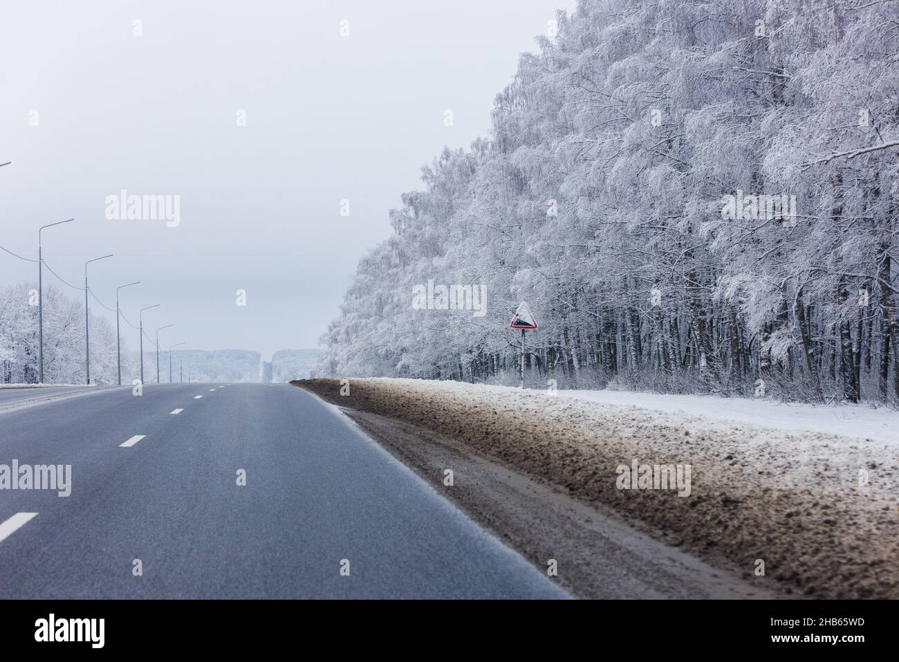 route d'hiver au milieu d'une forêt givrée à la lumière du jour, sans voitures Banque D'Images