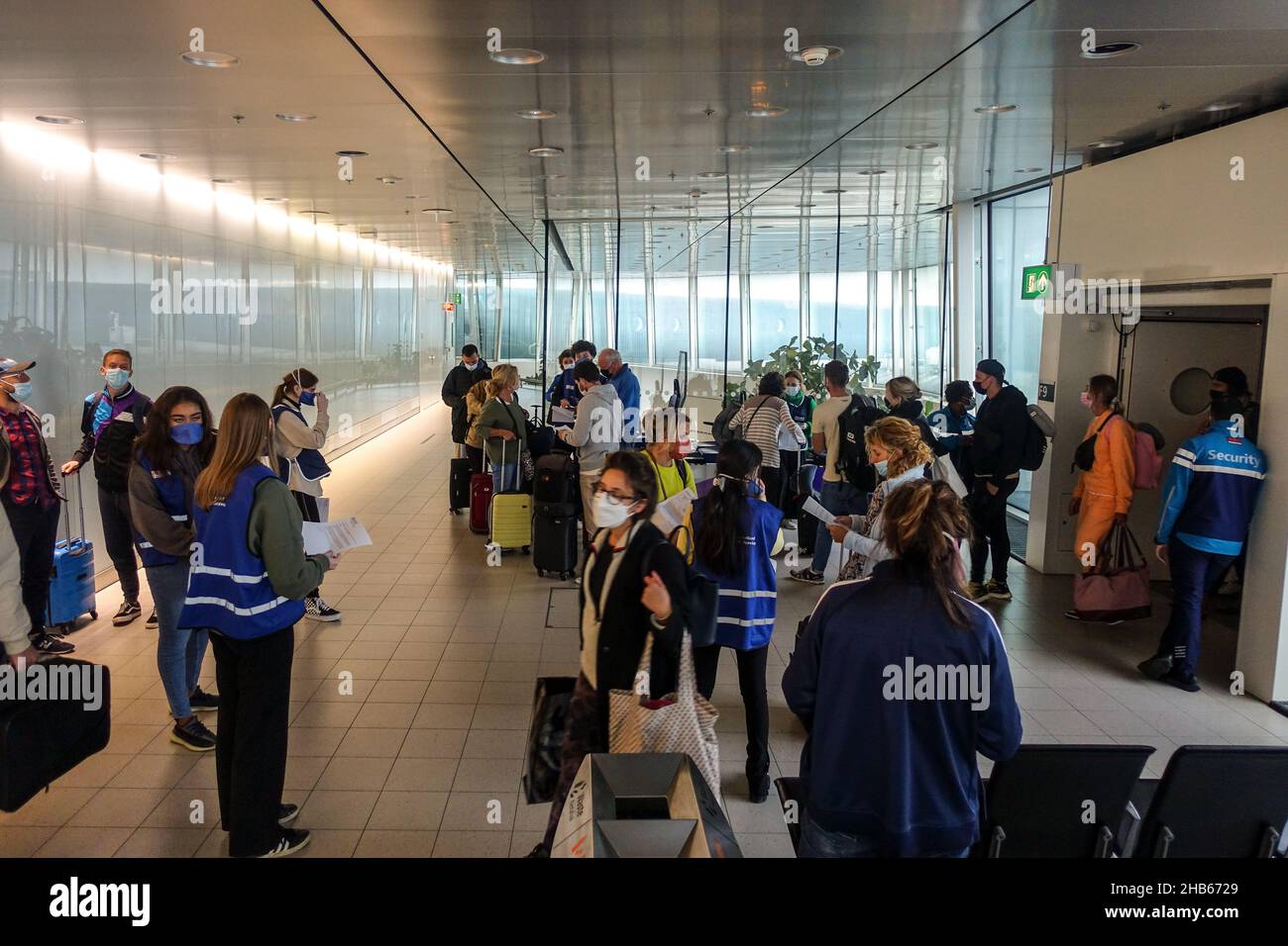 Aéroport international de Schiphol, Amsterdam, pays-Bas.9th décembre 2021.Le personnel dirige les passagers arrivant d'Afrique du Sud par le biais de tests PCR. Banque D'Images