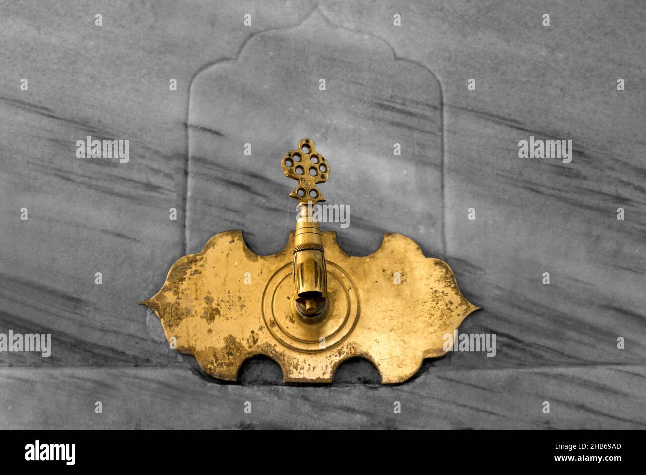 Robinet d'ablution antique de couleur dorée de style ottoman sur fond de marbre. Banque D'Images