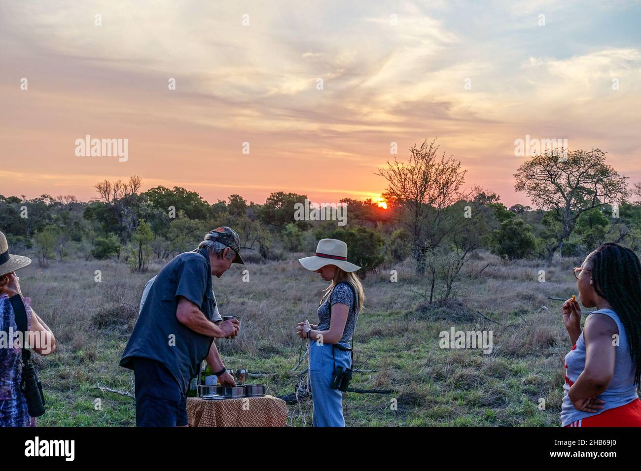 Touristes sur une route de jeu, voyage safari, parmi la faune du parc national Kruger, Afrique du Sud, prendre un verre au coucher du soleil Banque D'Images