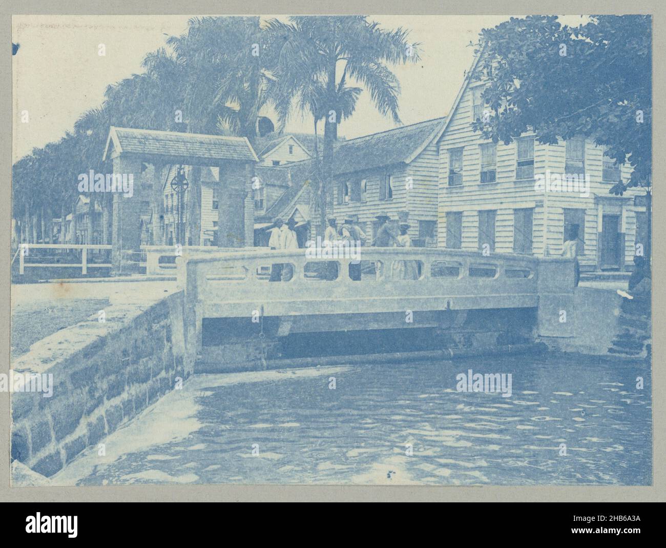 Mond Knuffelsgracht (titre sur objet), Pont au début du Knuffelsgracht à Paramaribo, sur le pont se dresse un groupe de personnes.Partie de l'album photo souvenir de Voyage (partie 2), sur la vie de la famille Doijer dans et autour de la plantation Ma Retraite au Suriname dans les années 1906-1913., Hendrik Doijer (attribué à), Suriname, 1906 - 1913, support photographique, cyanotype,hauteur 82 mm × largeur 111 mm Banque D'Images