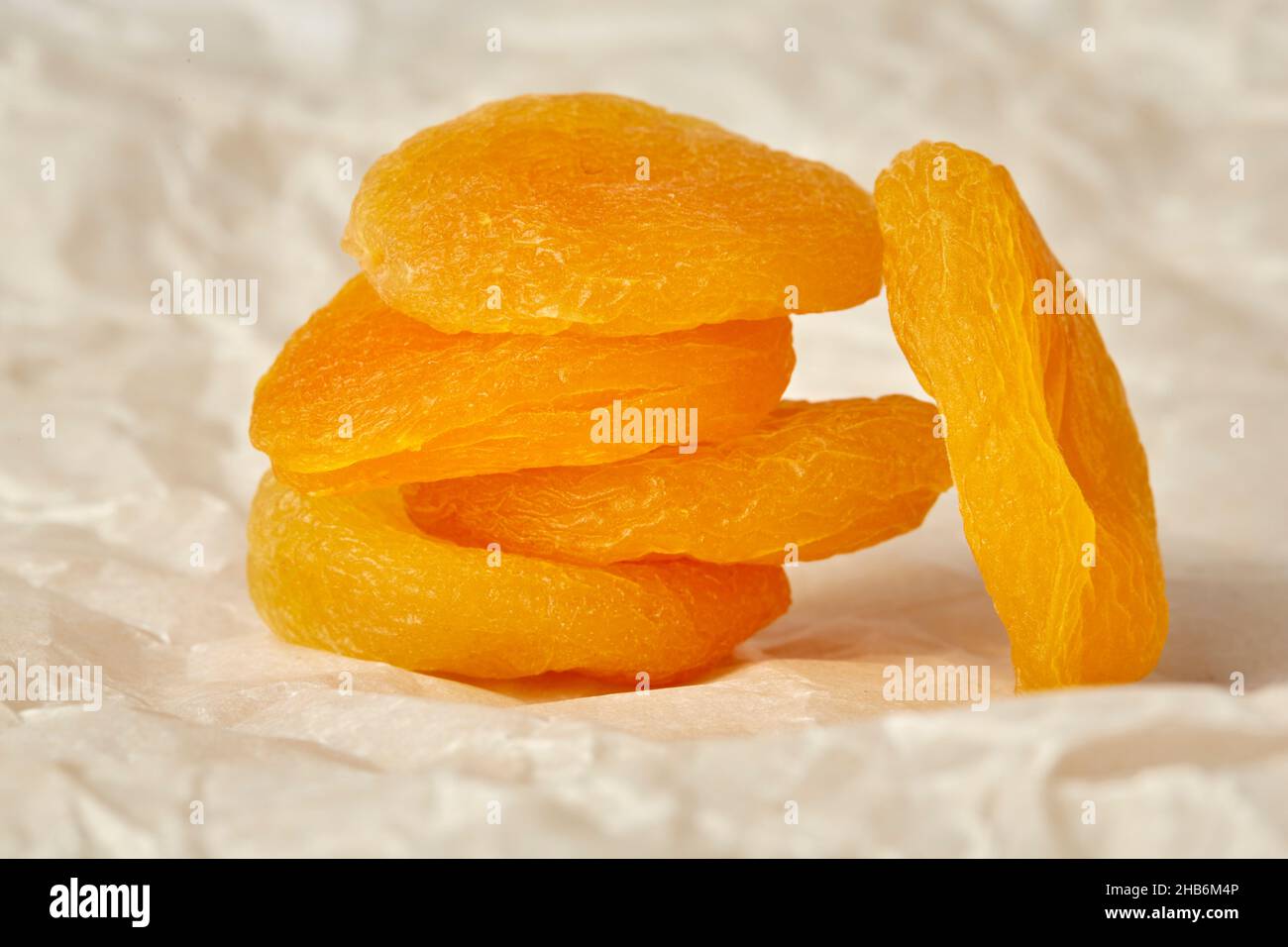 Photo d'abricots séchés sur fond de papier froissé, d'abricots séchés reposant sur des abricots séchés Banque D'Images