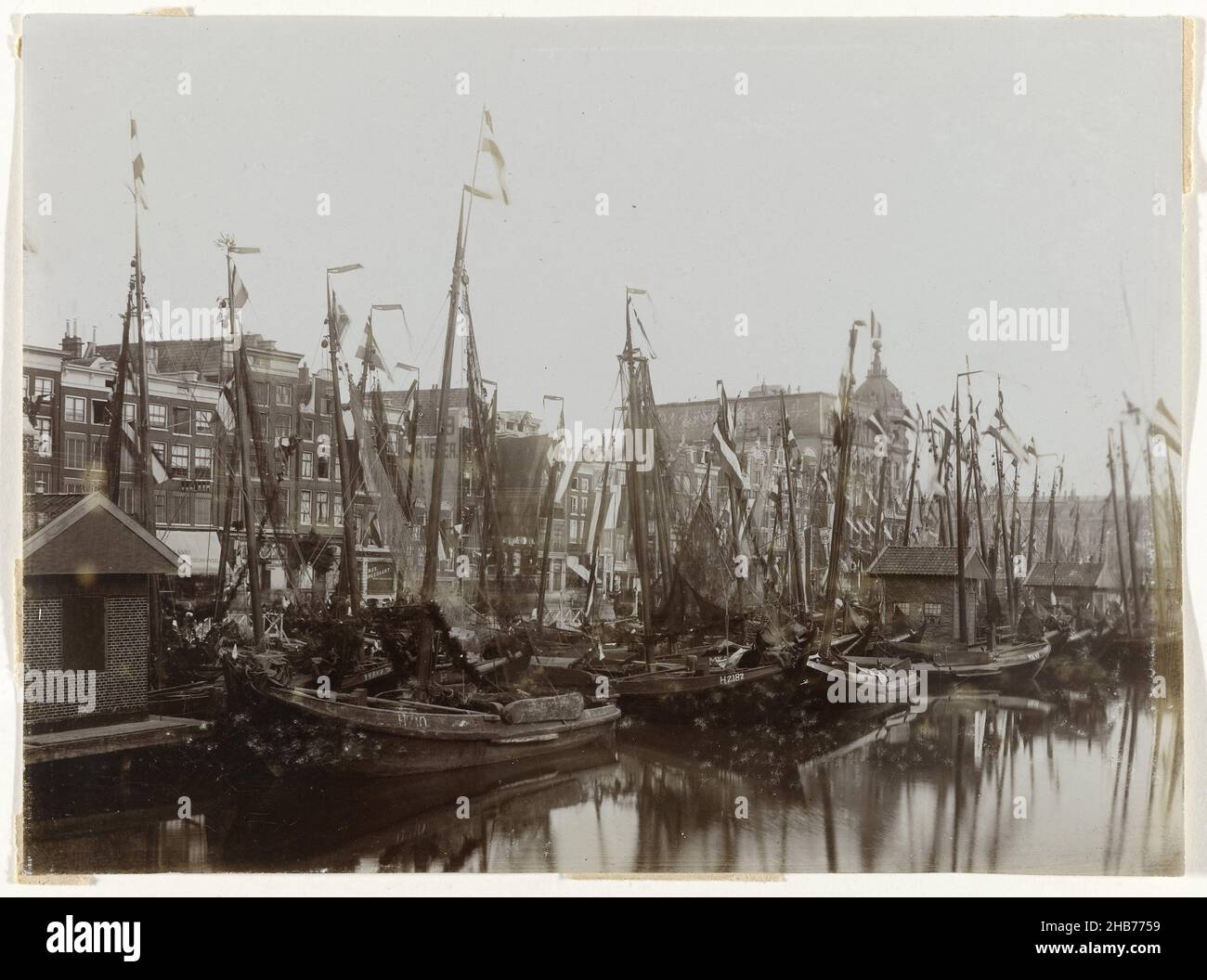 Bateaux dans le Damrak, décorés de drapeaux, à l'occasion de l'inauguration de la reine Wilhelmina, Amsterdam, pays-Bas, les bateaux dans le Damrak sont décorés de drapeaux à l'occasion de l'inauguration de la reine Wilhelmina.Des drapeaux sont également mis sur les maisons sur le Damrak et le Victoria Hotel (à droite).À l'extrême droite, une partie de la gare centrale, Amsterdam, pays-Bas, anonyme, Amsterdam,1898, support photographique, hauteur 120 mm × largeur 162 mm Banque D'Images