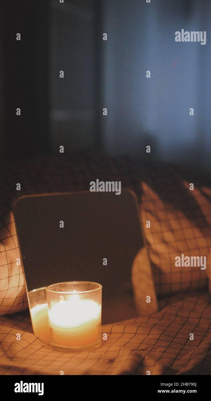Plan vertical d'une bougie devant un petit miroir sur un lit, esthétique  artistique Photo Stock - Alamy