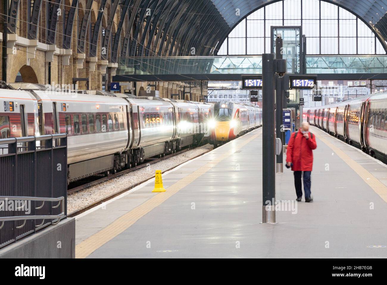 Passager en blouson rouge quittant le train ZUMA à la gare King's Cross en Angleterre Banque D'Images