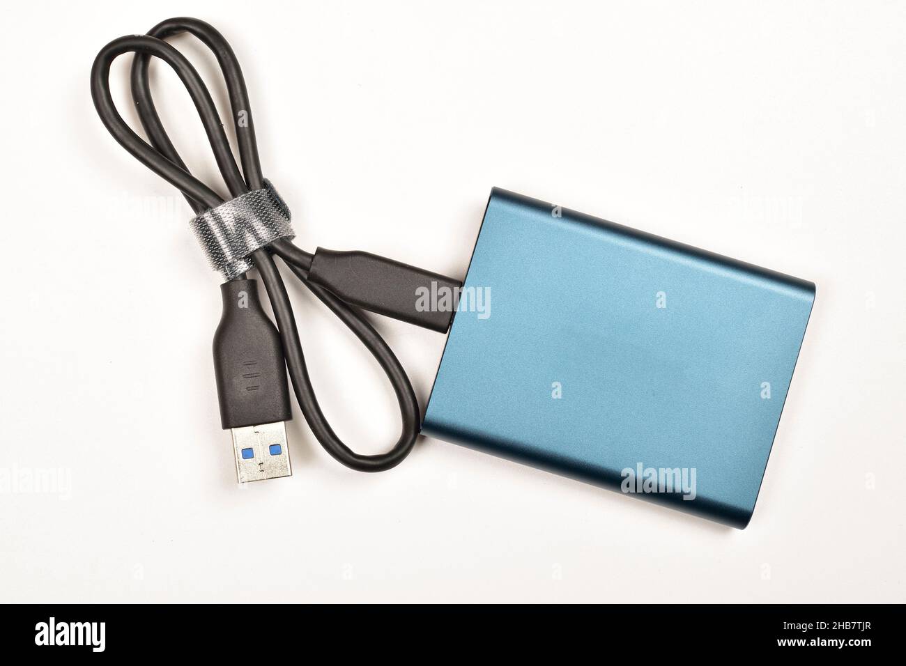 Disque SSD externe avec câble isolé sur fond blanc Banque D'Images