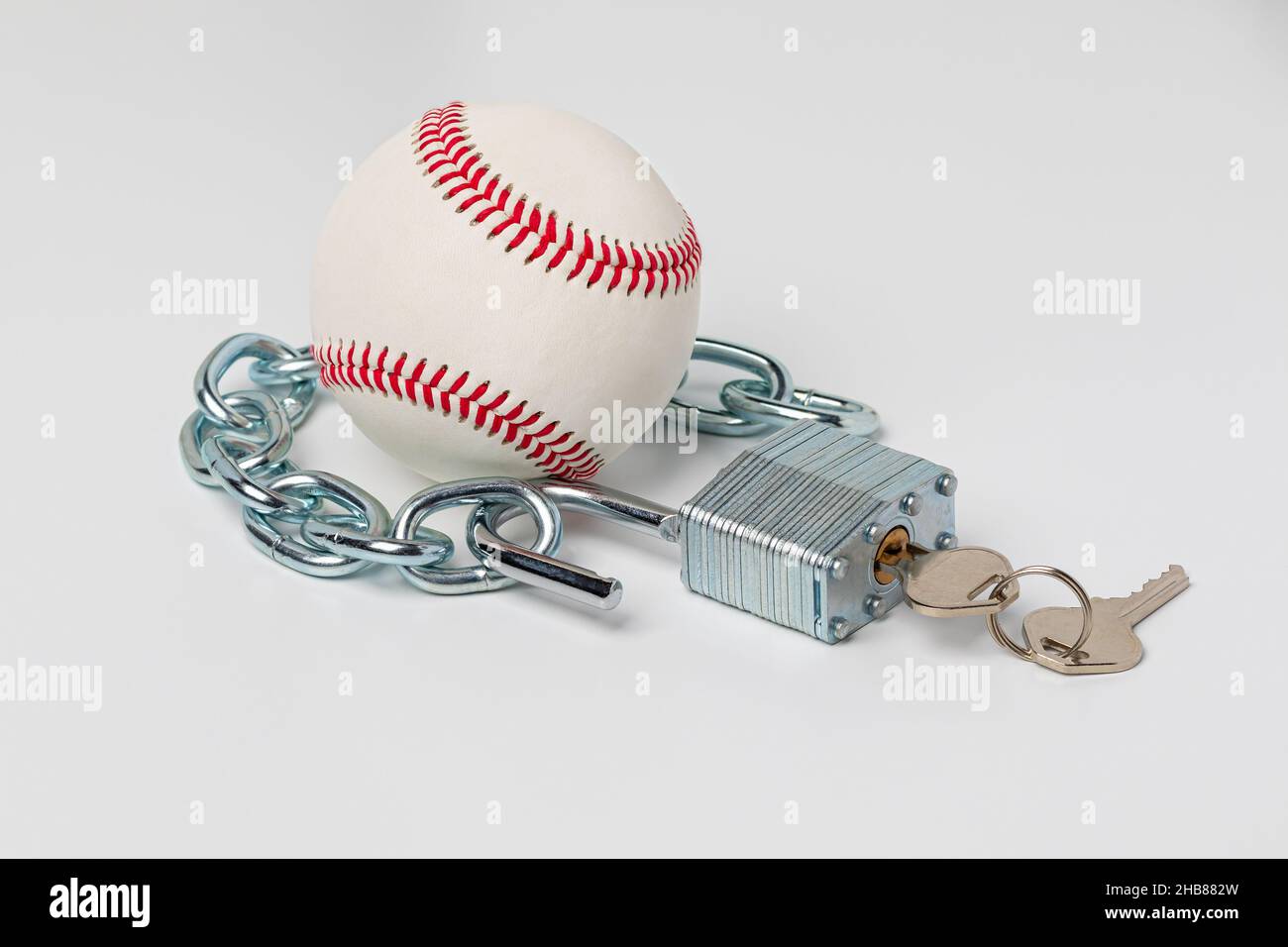Base-ball avec chaîne et serrure ouverte.Concept de grève de baseball, de lock-out et d'accord de travail. Banque D'Images