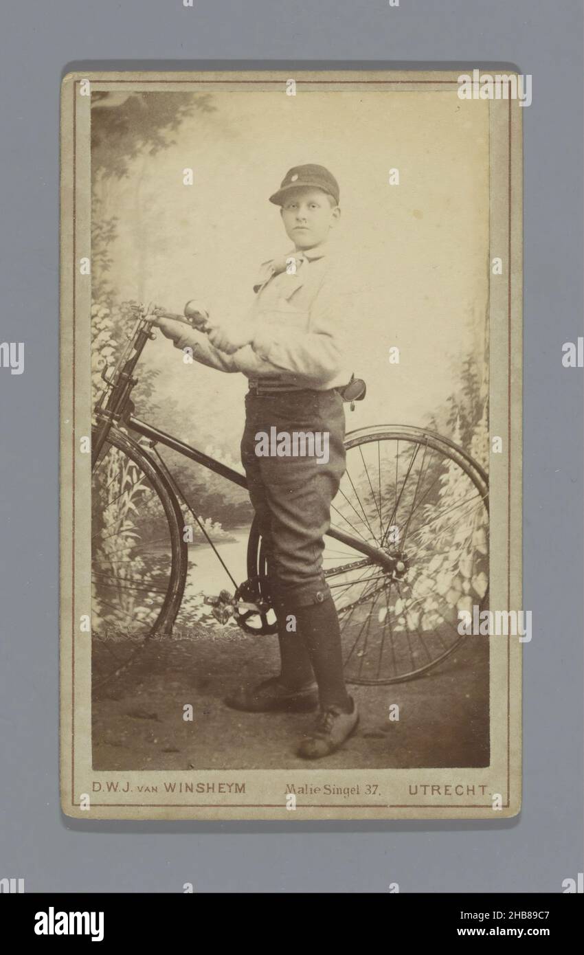 Portrait d'un garçon inconnu (vraisemblablement) en uniforme de scout, tenant une bicyclette, D.W.J. van Wincheijm (mentionné sur l'objet), Utrecht, c.1878 - c.1895, carton, imprimé albumine, hauteur 93 mm × largeur 55 mm Banque D'Images